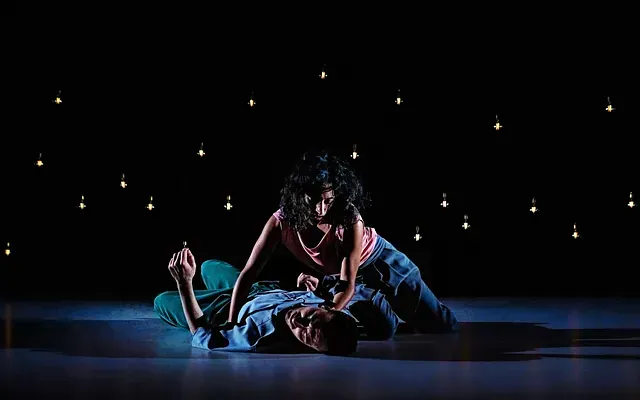 Un hombre y una mujer están acostados en el suelo en una habitación oscura.