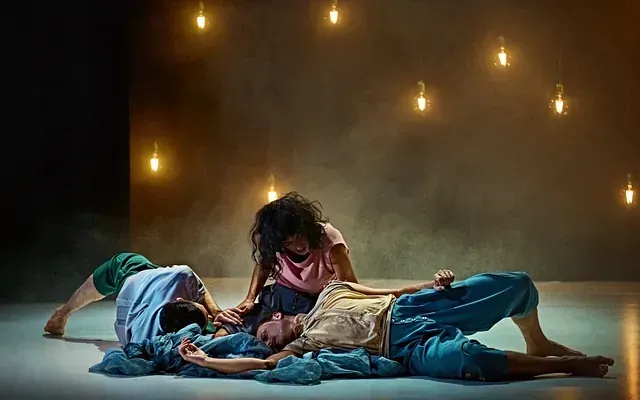 Un grupo de personas están acostadas una encima de la otra en un escenario.