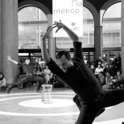 Un hombre está bailando frente a una multitud en una foto en blanco y negro.