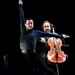 Dos hombres tocan el violonchelo y el violín en un escenario.