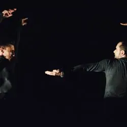 Un grupo de hombres están parados uno al lado del otro en la oscuridad.