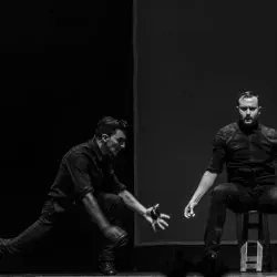 Dos hombres están bailando en un escenario en una foto en blanco y negro.