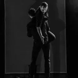 Un hombre lleva a una mujer en su espalda en una fotografía en blanco y negro.