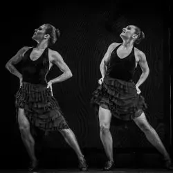 Dos mujeres bailan flamenco en un escenario en una foto en blanco y negro.