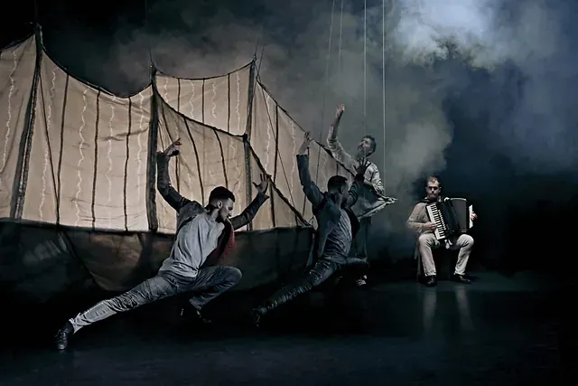 Un grupo de personas está bailando en un escenario frente a una carpa.