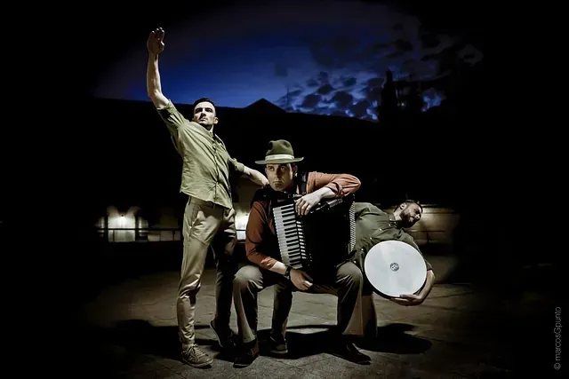 Un grupo de hombres están parados uno al lado del otro en una habitación oscura.