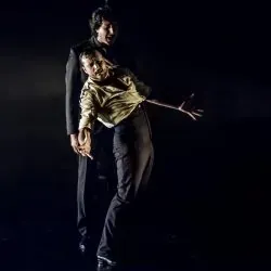 Un hombre y una mujer bailan juntos en una habitación oscura.