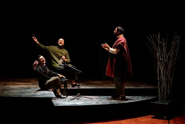 Un grupo de hombres está de pie en un escenario en una habitación oscura.