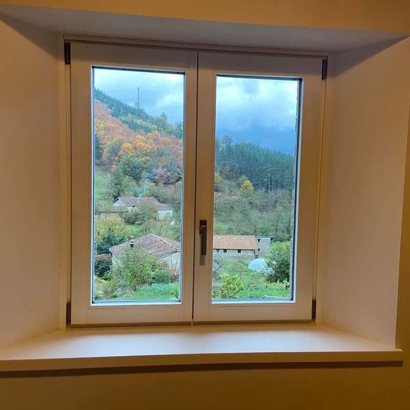 Una ventana con vista a un pueblo en las montañas.