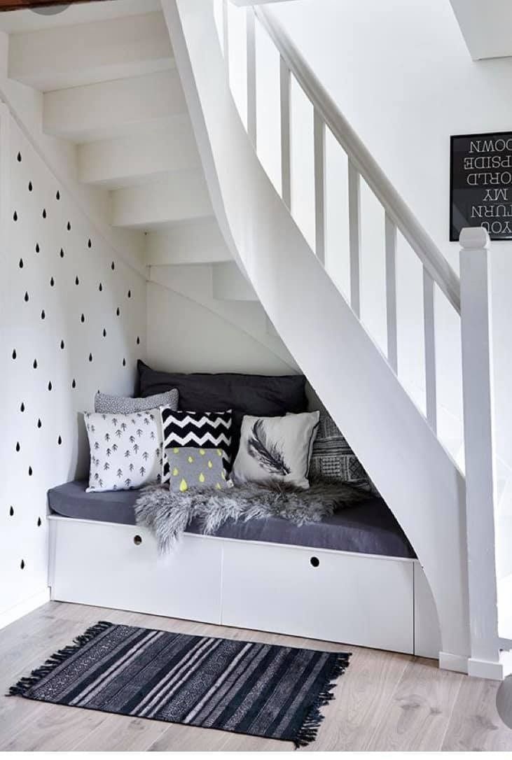 Una escalera blanca con un sofá debajo.