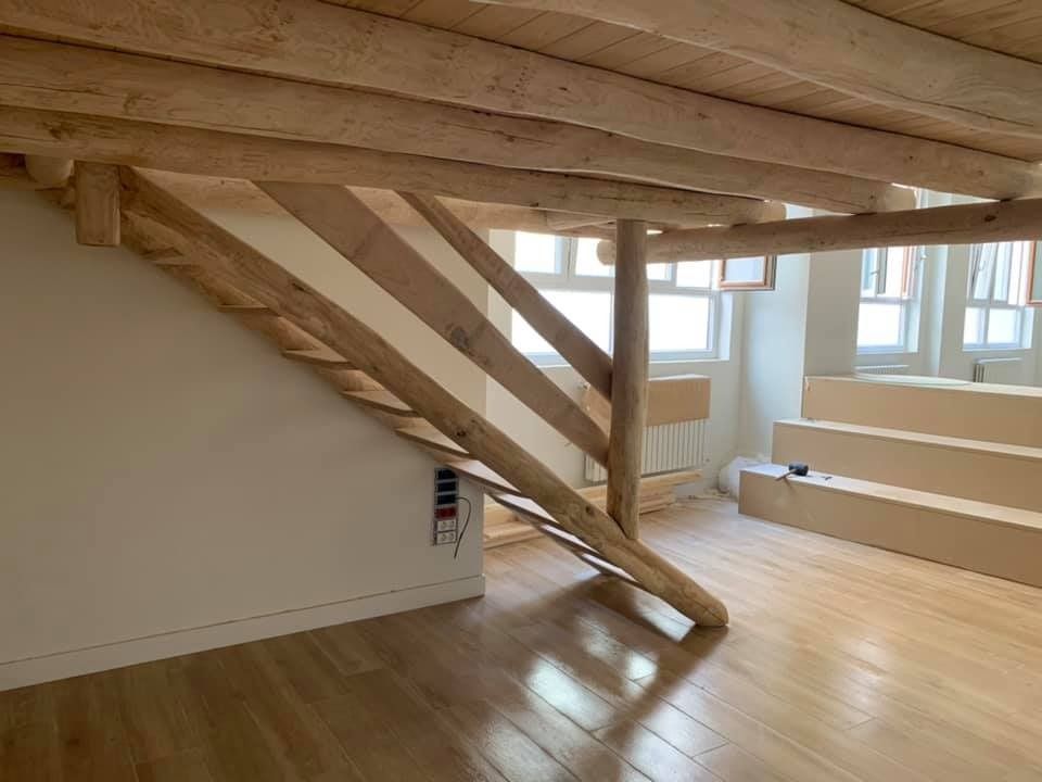 Hay una escalera de madera en el medio de la habitación.