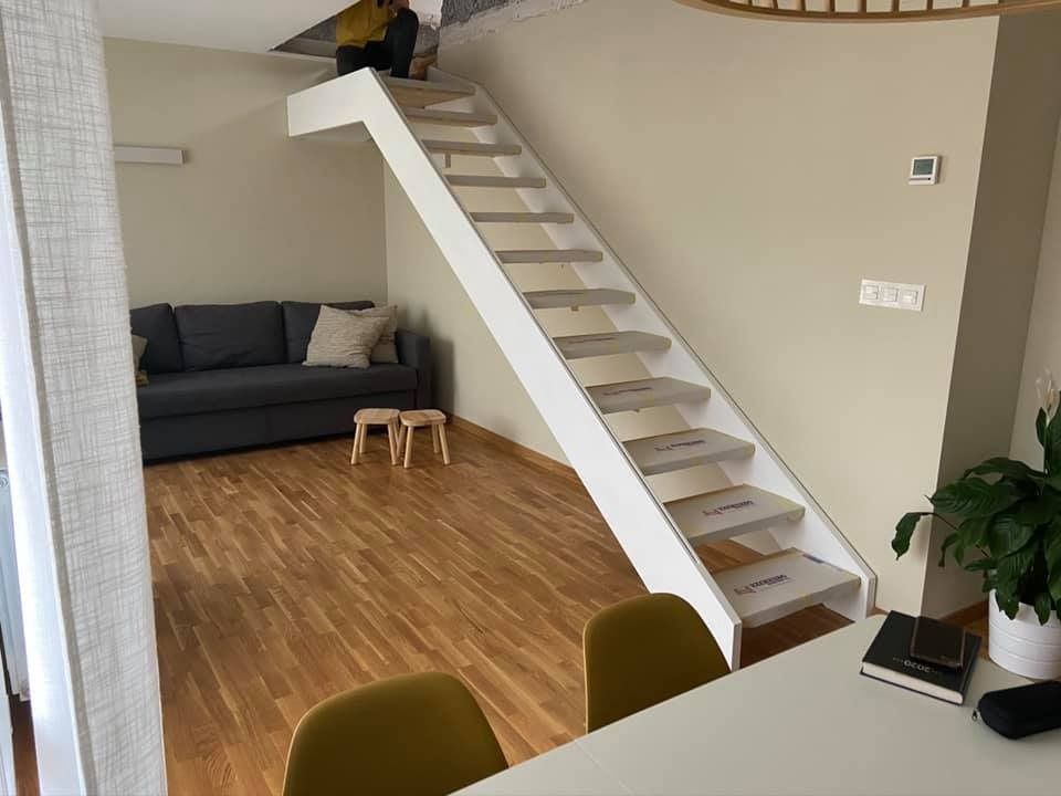 Una persona está parada en una escalera en una sala de estar.