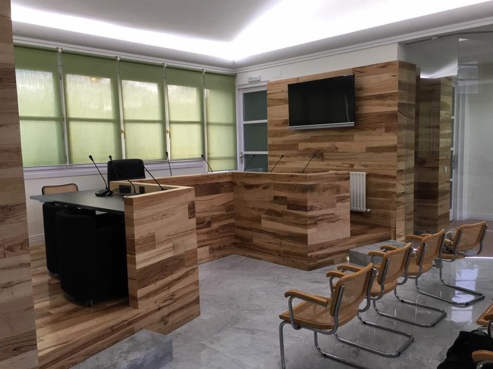 Una habitación con paredes de madera y sillas y un televisor en la pared.