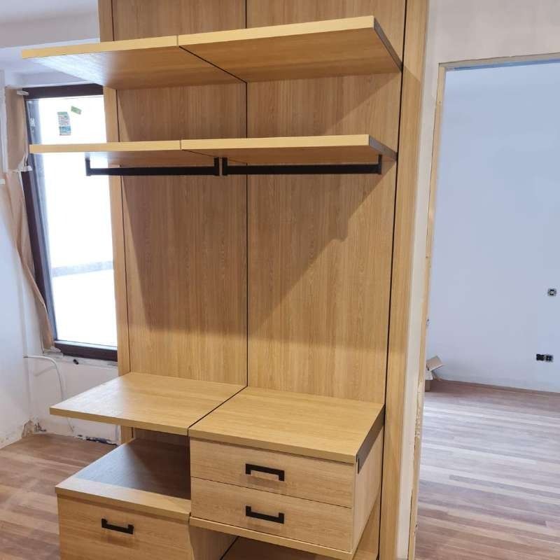 Un armario de madera con estantes y cajones y una ventana.