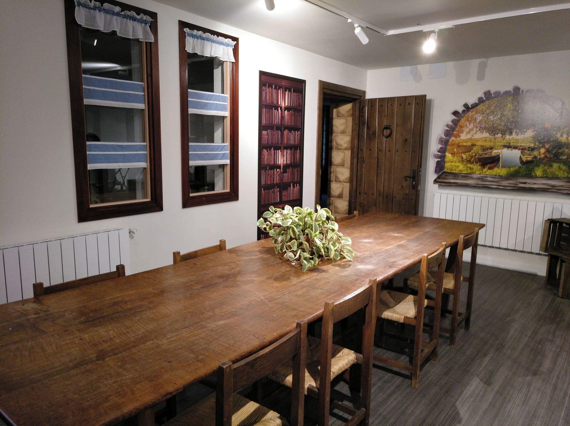 Un comedor con una larga mesa de madera y sillas.