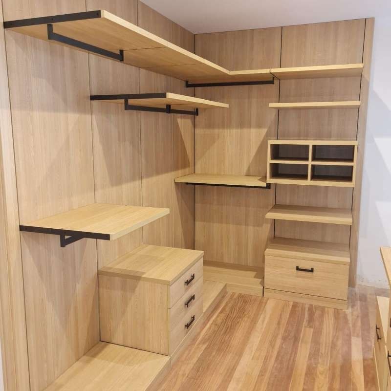 Un vestidor con estantes y cajones de madera.