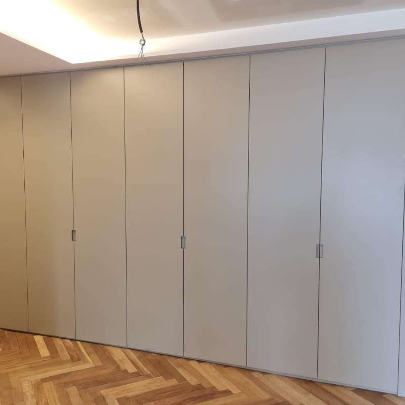 Una habitación con piso de madera y una pared de armarios.