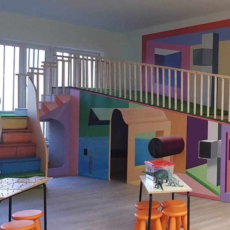 Una habitación con una escalera y una mesa con un dinosaurio encima.