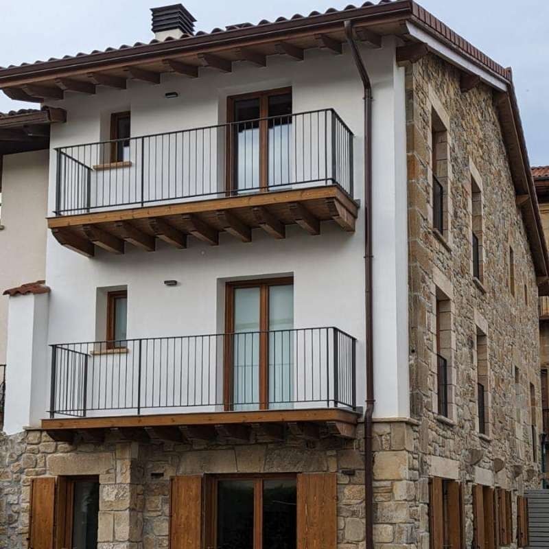 Un edificio blanco con un balcón en el segundo piso.