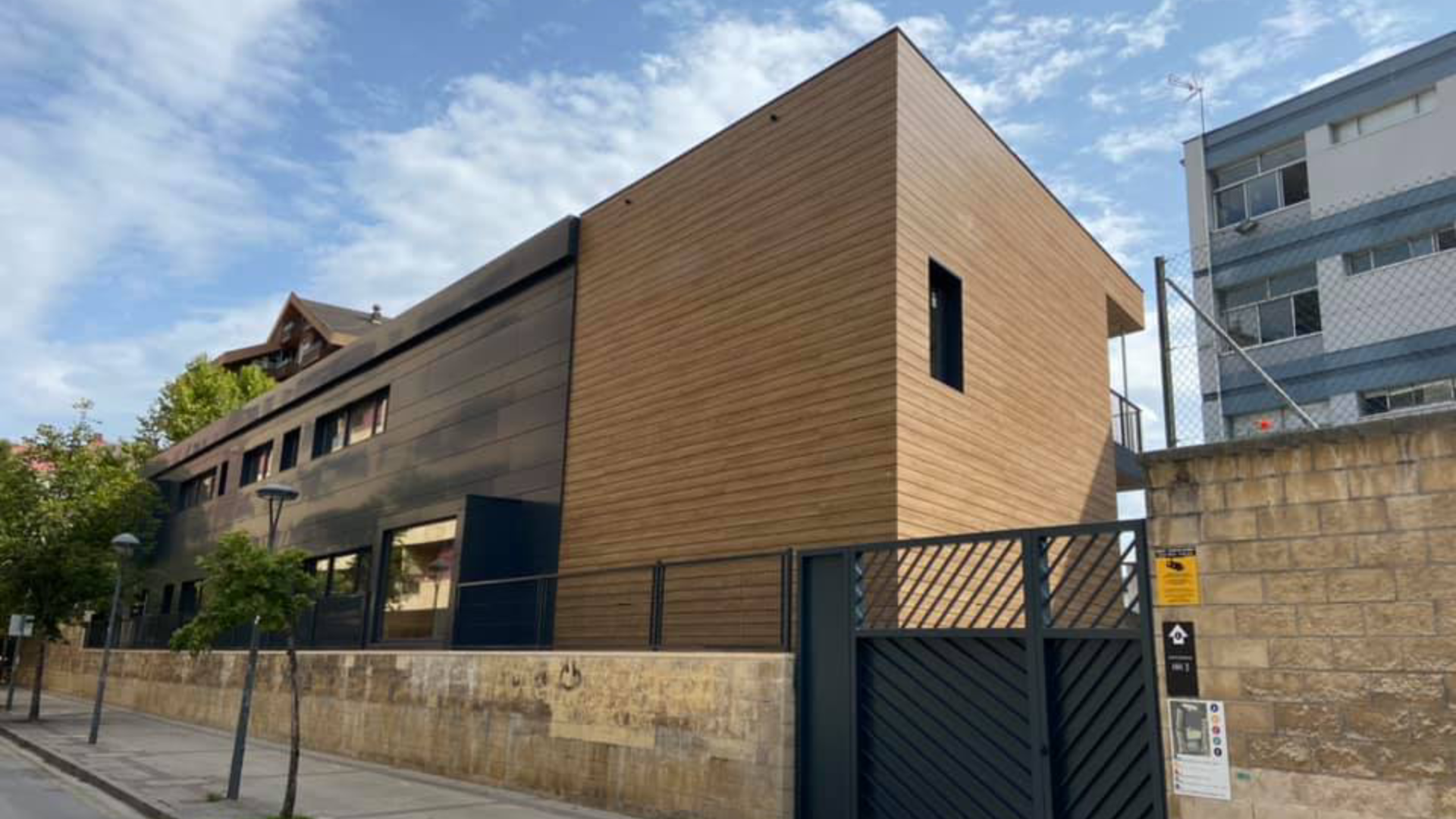 Un gran edificio de ladrillo con una puerta negra delante.