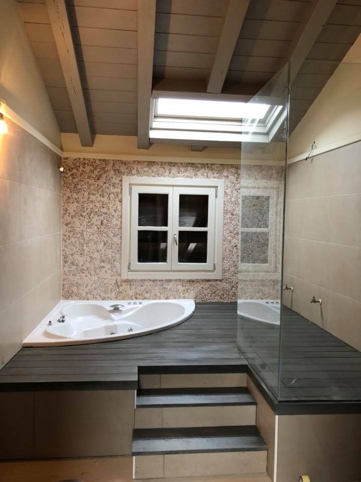 Un baño con bañera de hidromasaje y ducha a ras de suelo.
