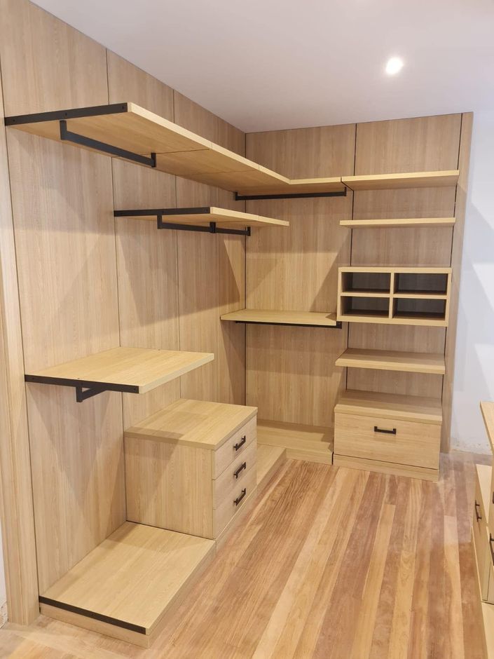 Un vestidor con estantes y cajones de madera.