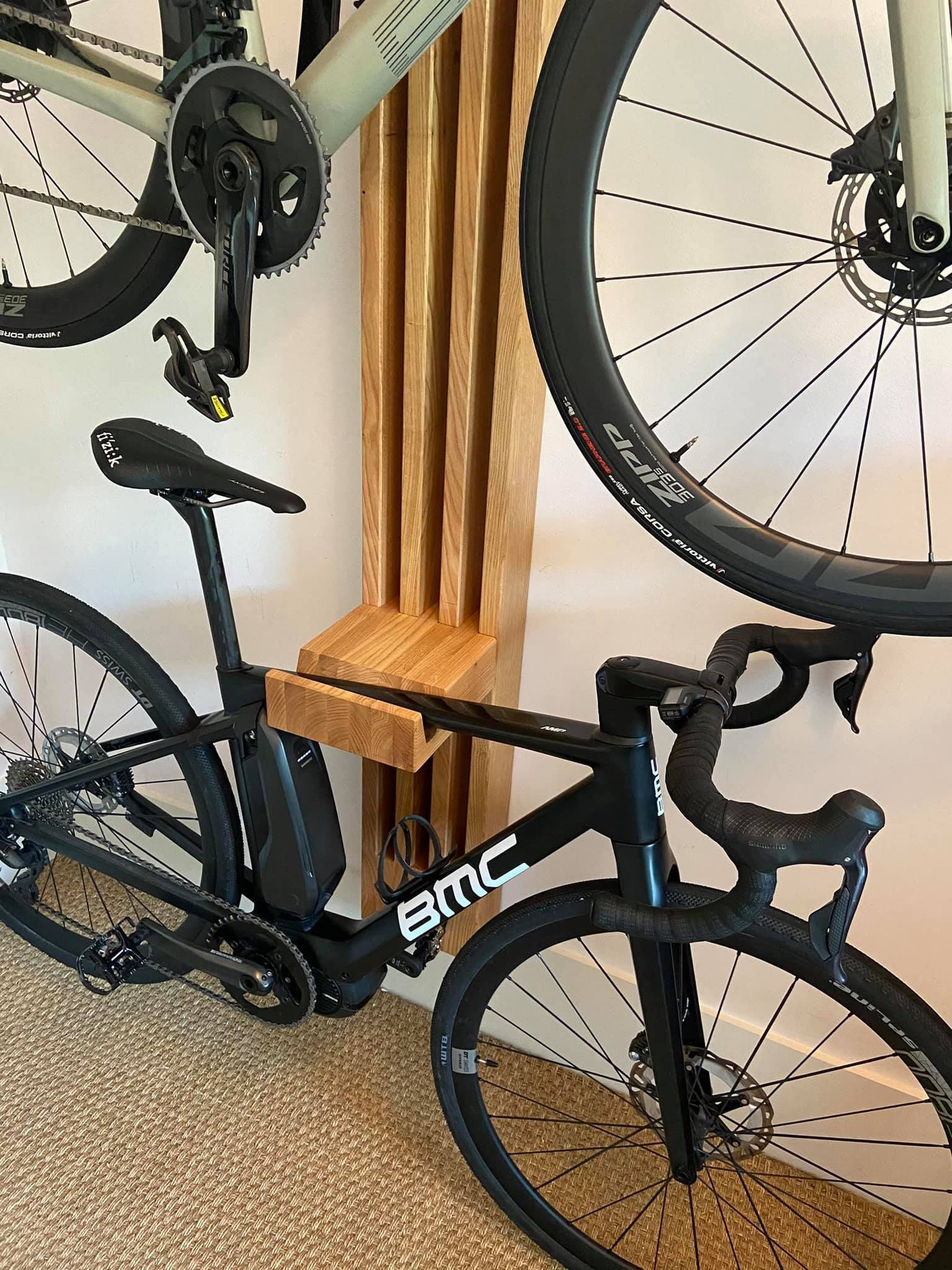 Una bicicleta está colgada en una pared al lado de otra bicicleta.
