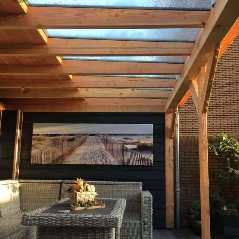 Un patio con una mesa, sillas y un cuadro en la pared.