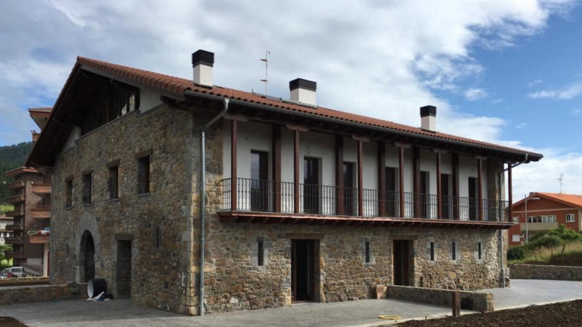 Un gran edificio de piedra con techo de tejas rojas.