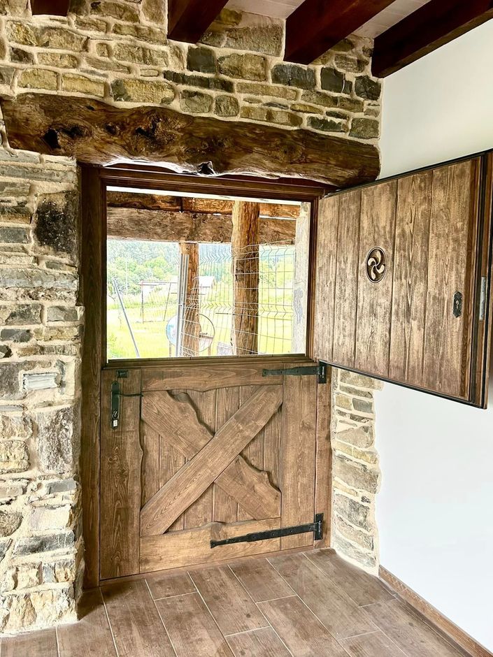 Una habitación con una puerta de madera y una pared de ladrillo.