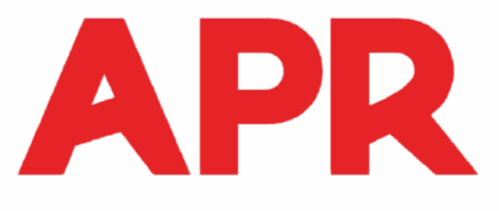 Une personne en pantalon bleu et bottines passe l'aspirateur sur un tapis, un aspirateur jaune étant visible en arrière-plan.