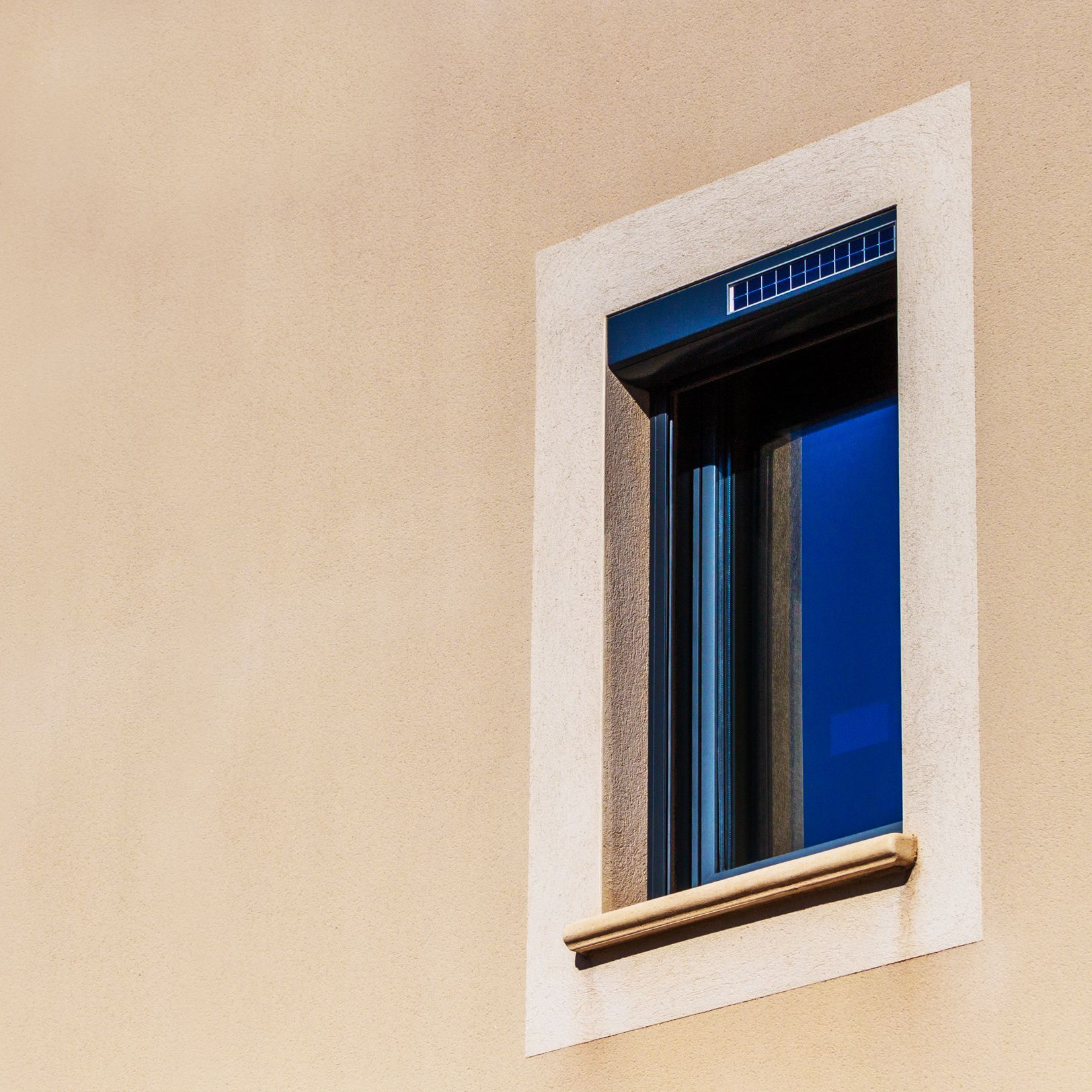 Une fenêtre avec un encadrement beige clair.