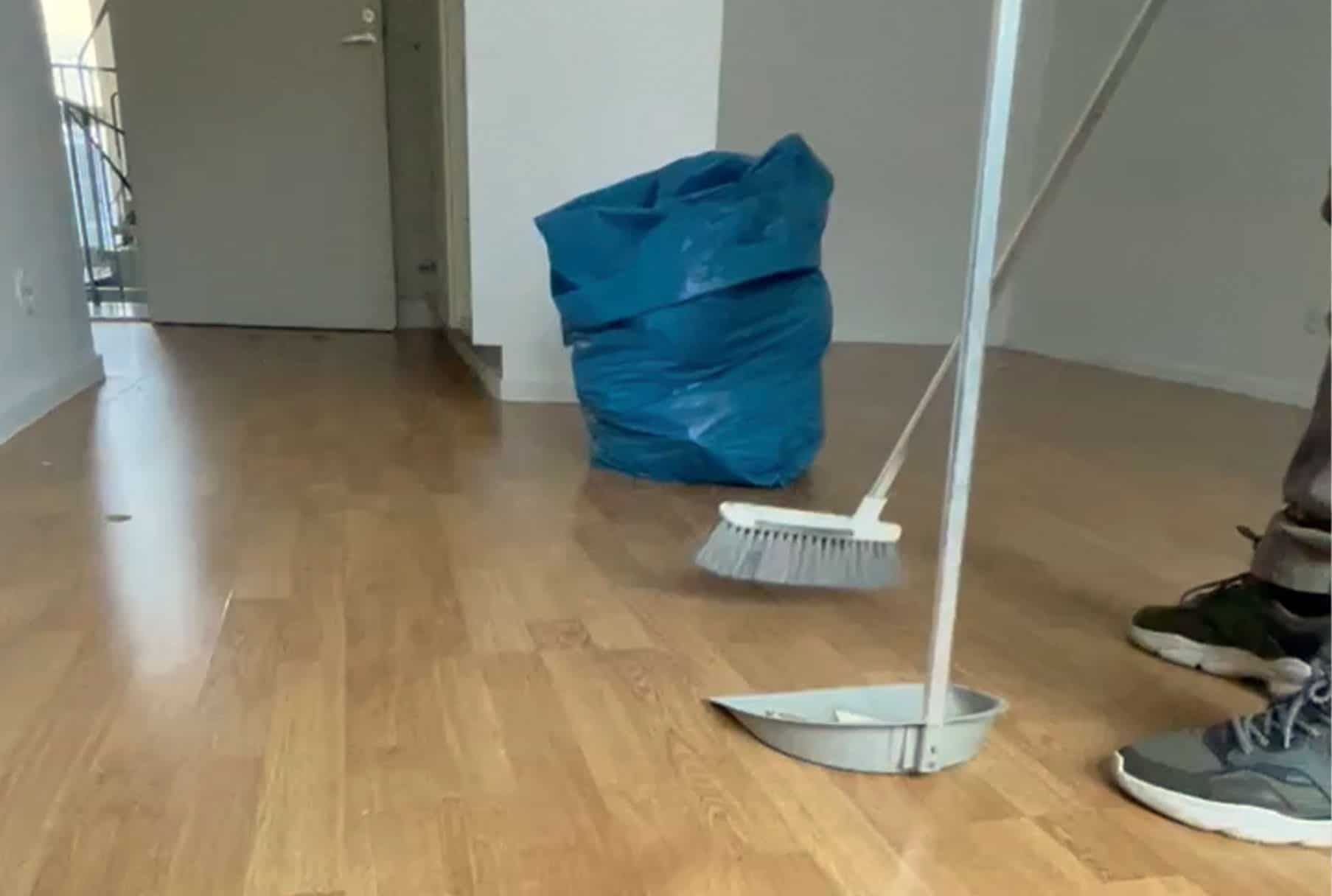 Moderni valkoinen talo mustilla yksityiskohdilla ja puisella terassilla, sininen taivas yläpuolella.