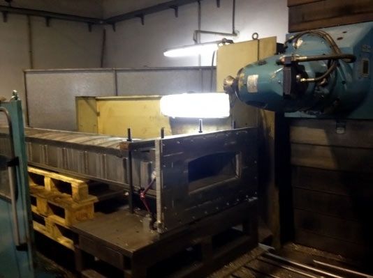 Máquina industrial con una luz brillante en el piso de una fábrica.