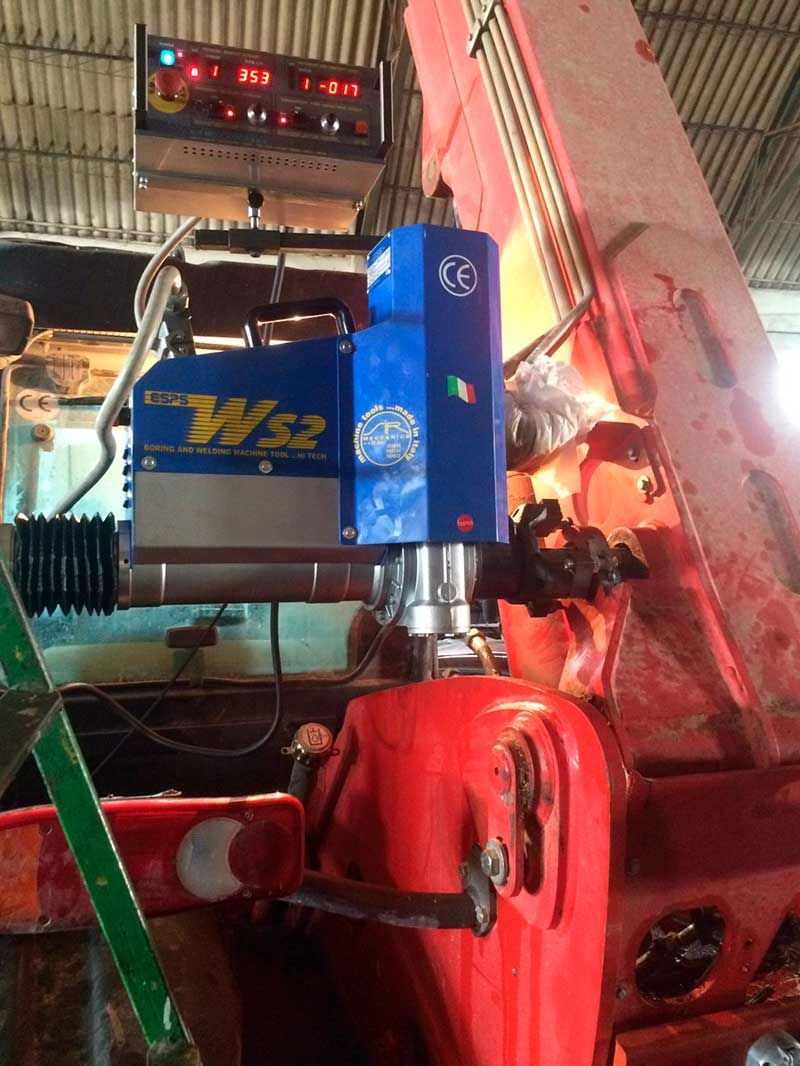 Maquinaria W32 azul y plateada con pegatina de bandera italiana sobre equipo rojo y una pantalla digital encima.