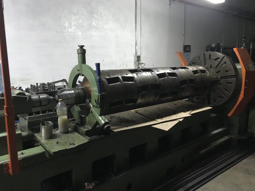 Un gran cilindro de metal en un torno dentro de un taller.