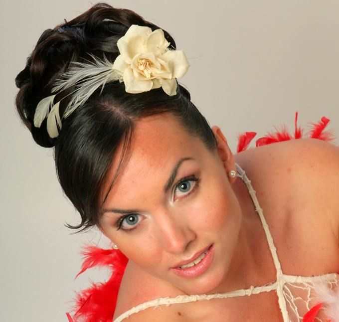 Una mujer con plumas y una flor en el pelo