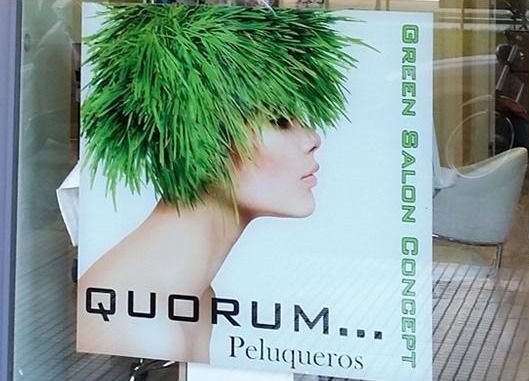Un cartel de una mujer con cabello verde dice quorum peluqueros