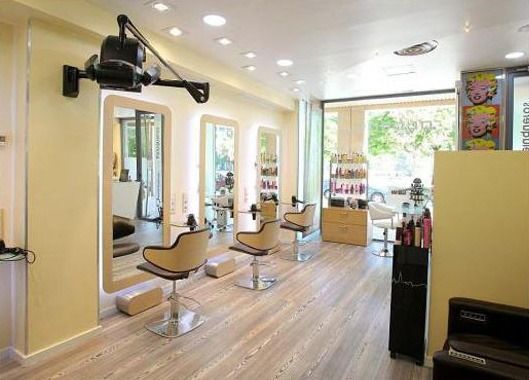 Una peluquería con muchas sillas y espejos.