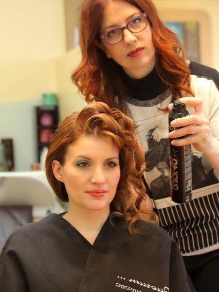 Una mujer pelirroja se está peinando en la peluquería.