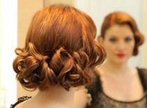 Una mujer con cabello rojo se mira en un espejo.