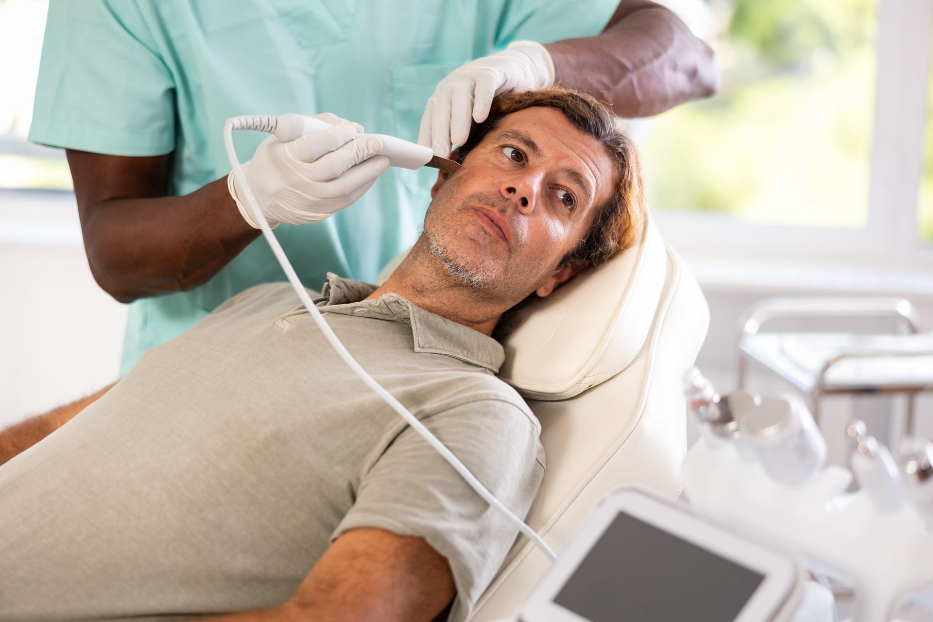 Un uomo è sdraiato su una sedia mentre riceve una cura da un medico.