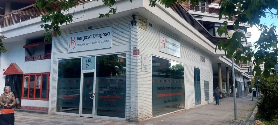 Un hombre está parado frente a un edificio con un cartel que dice 