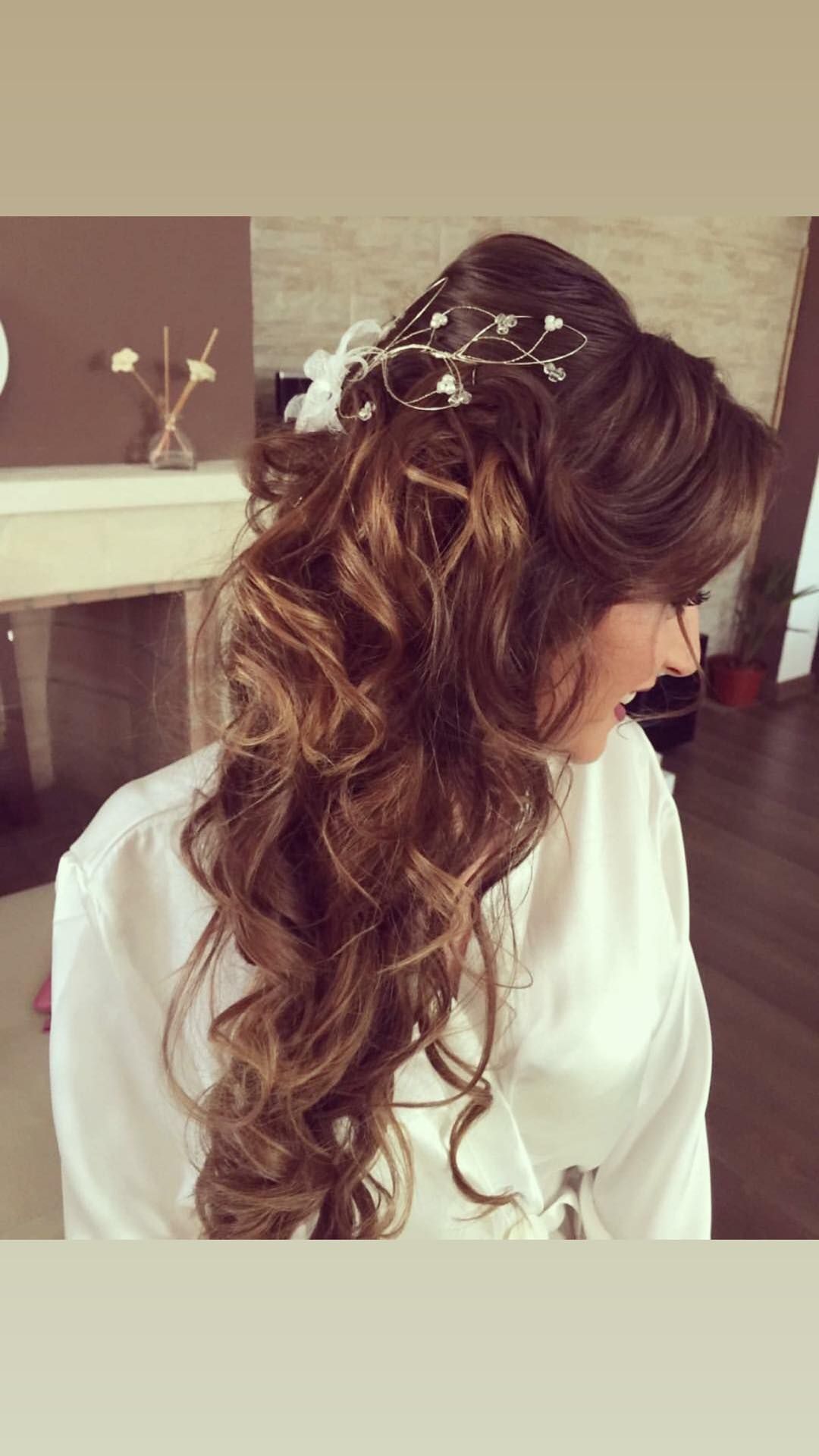 Mujer con cabello castaño largo y ondulado, peinado en un recogido con un peluquín decorativo y rizos hacia los lados.