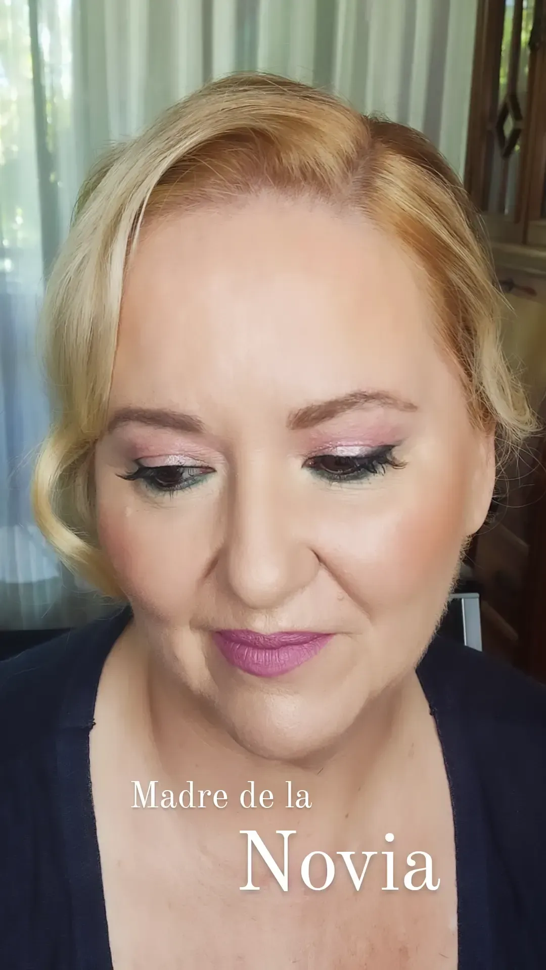 Mujer con peinado rubio recogido y maquillaje, el texto dice 