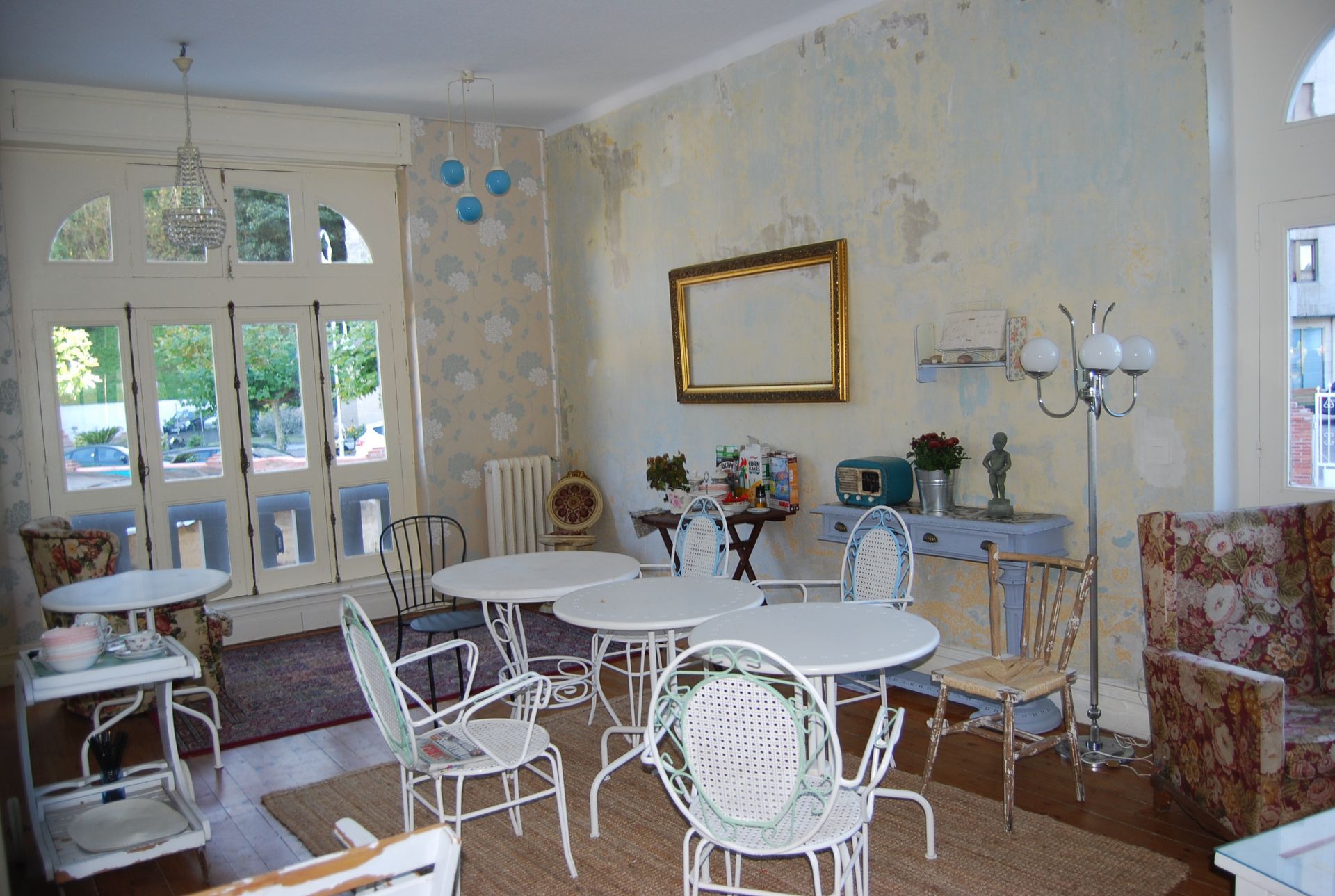 Una sala de estar con mesas y sillas y un espejo en la pared.