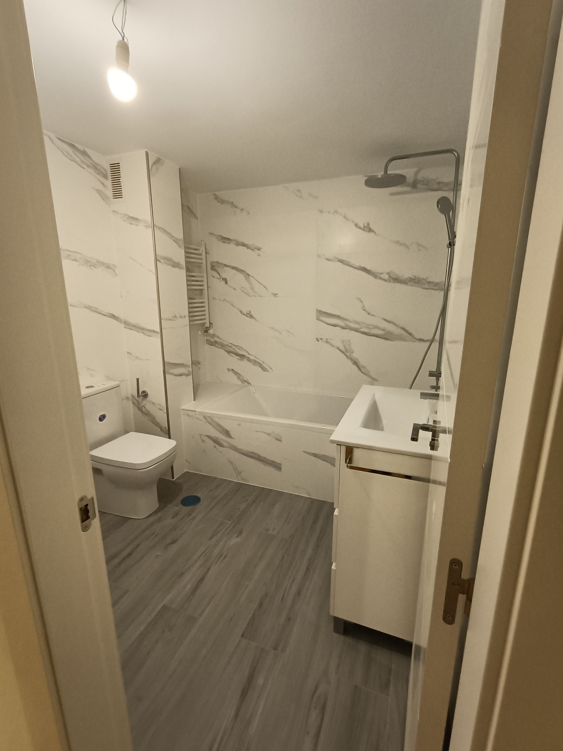 Un baño con inodoro, lavabo, bañera y ducha.