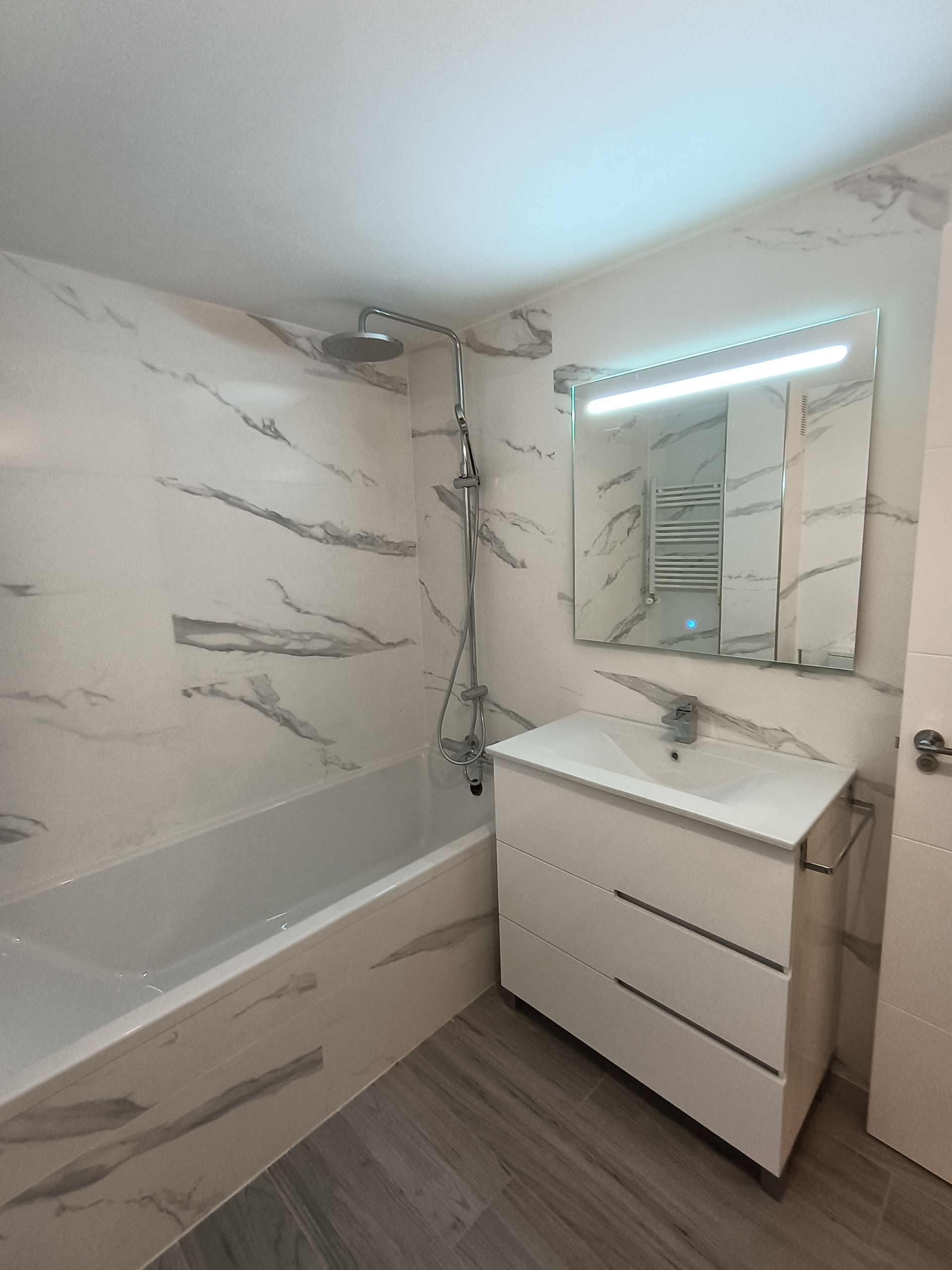 Un baño con bañera, lavabo y espejo.