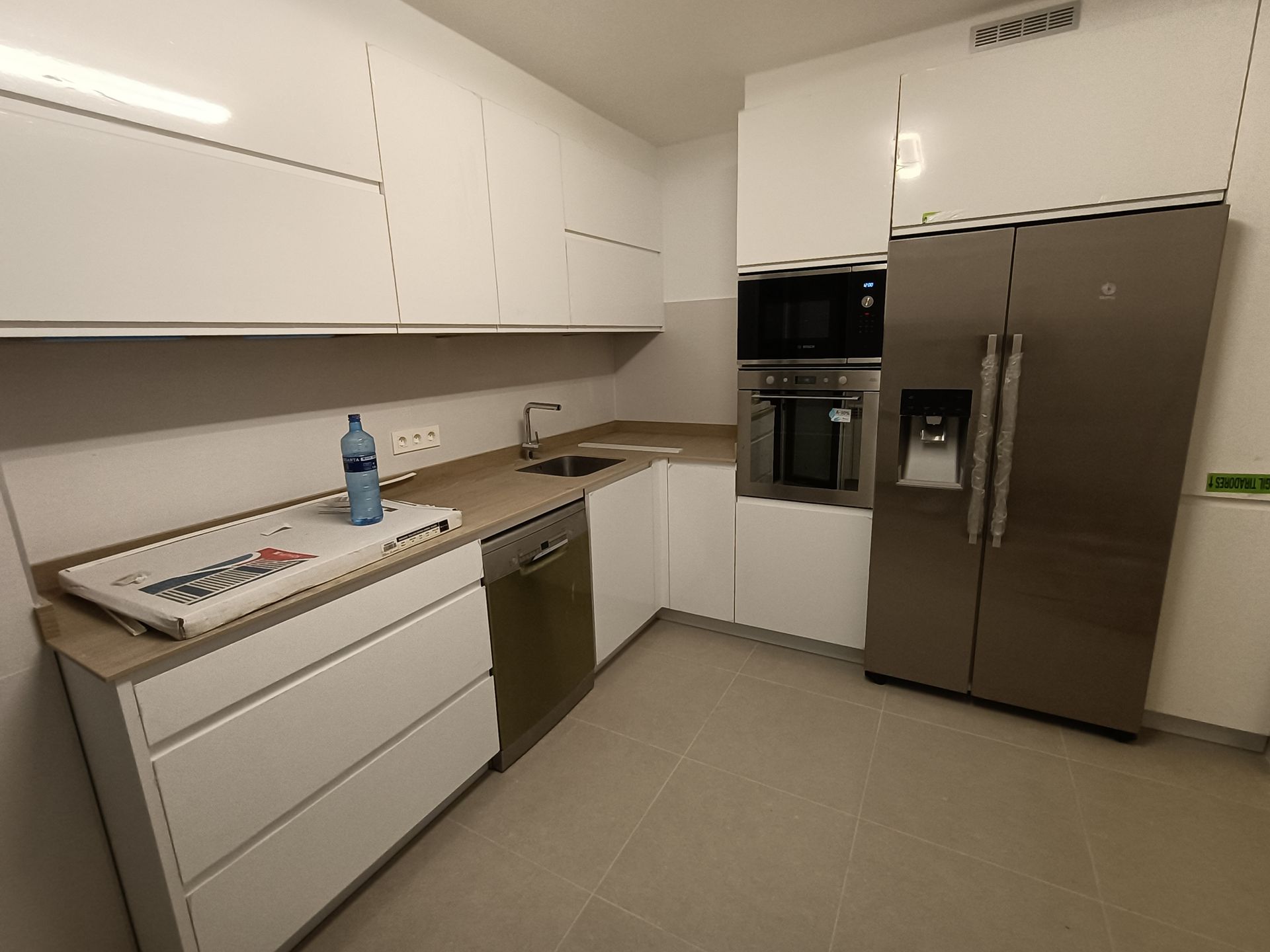 Una cocina con electrodomésticos de acero inoxidable y gabinetes blancos.