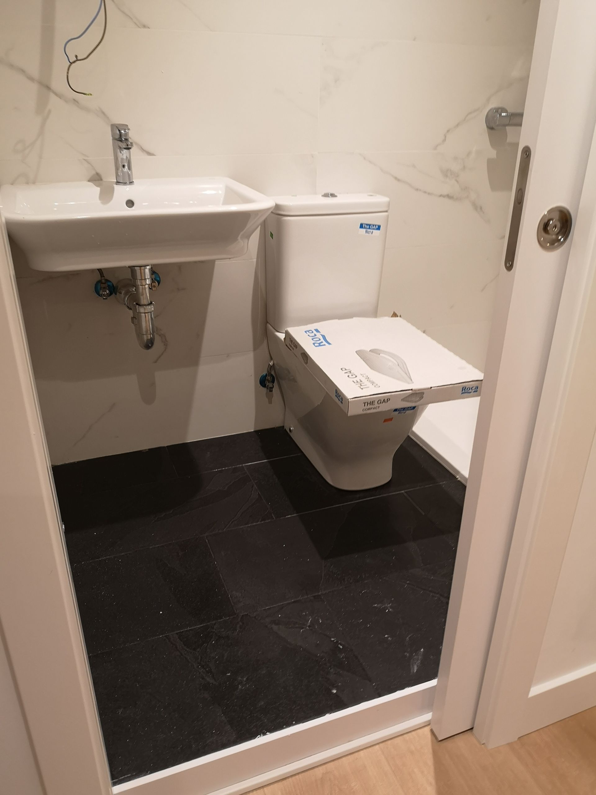 Un baño con inodoro, lavabo y espejo.